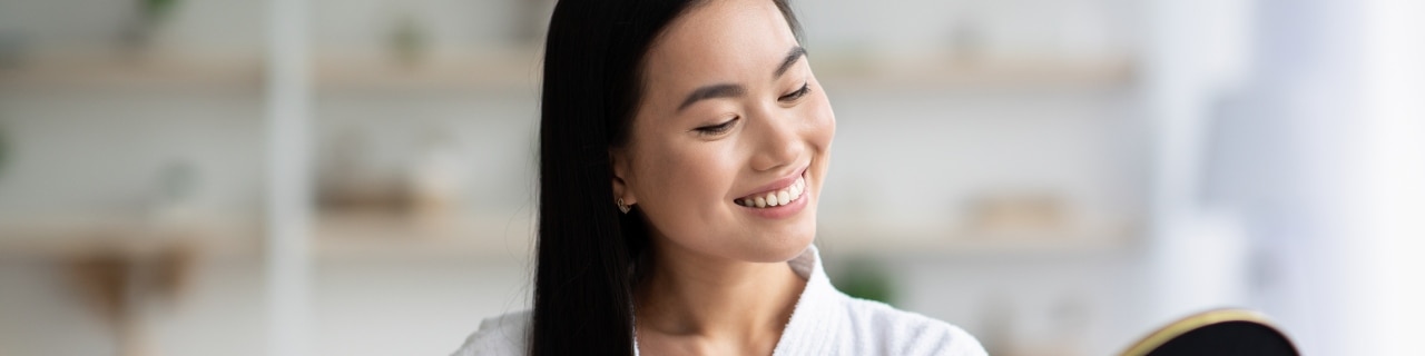 Mulher penteando os cabelos enquanto faz sua nutrição capilar
