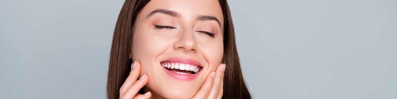 Mulher sorridente após sua rotina de skin care, com pele hidratada, saudável e protegida.