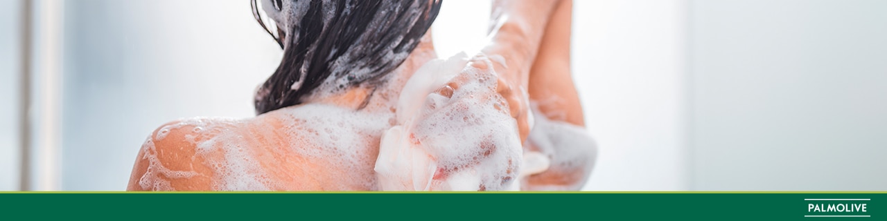 Mulher lavando as costas com sabonete para banho