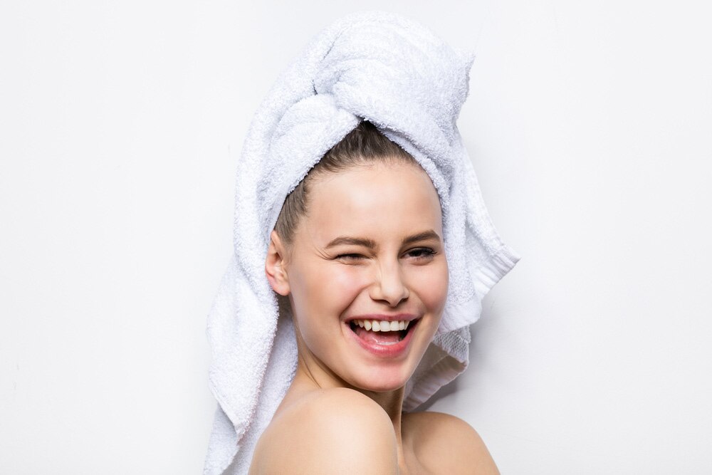 Mujer con el cabello limpio recogido en una toalla